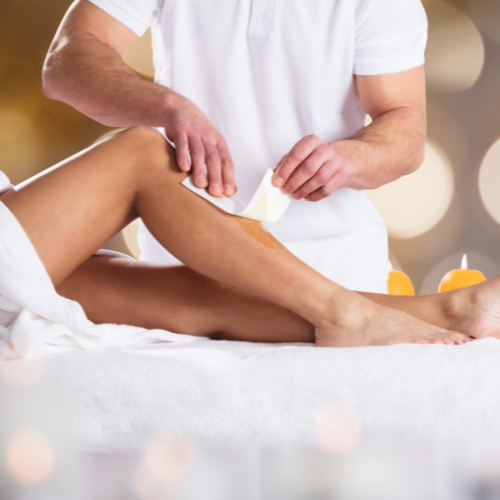 woman having leg hair removal treatment with wax tape