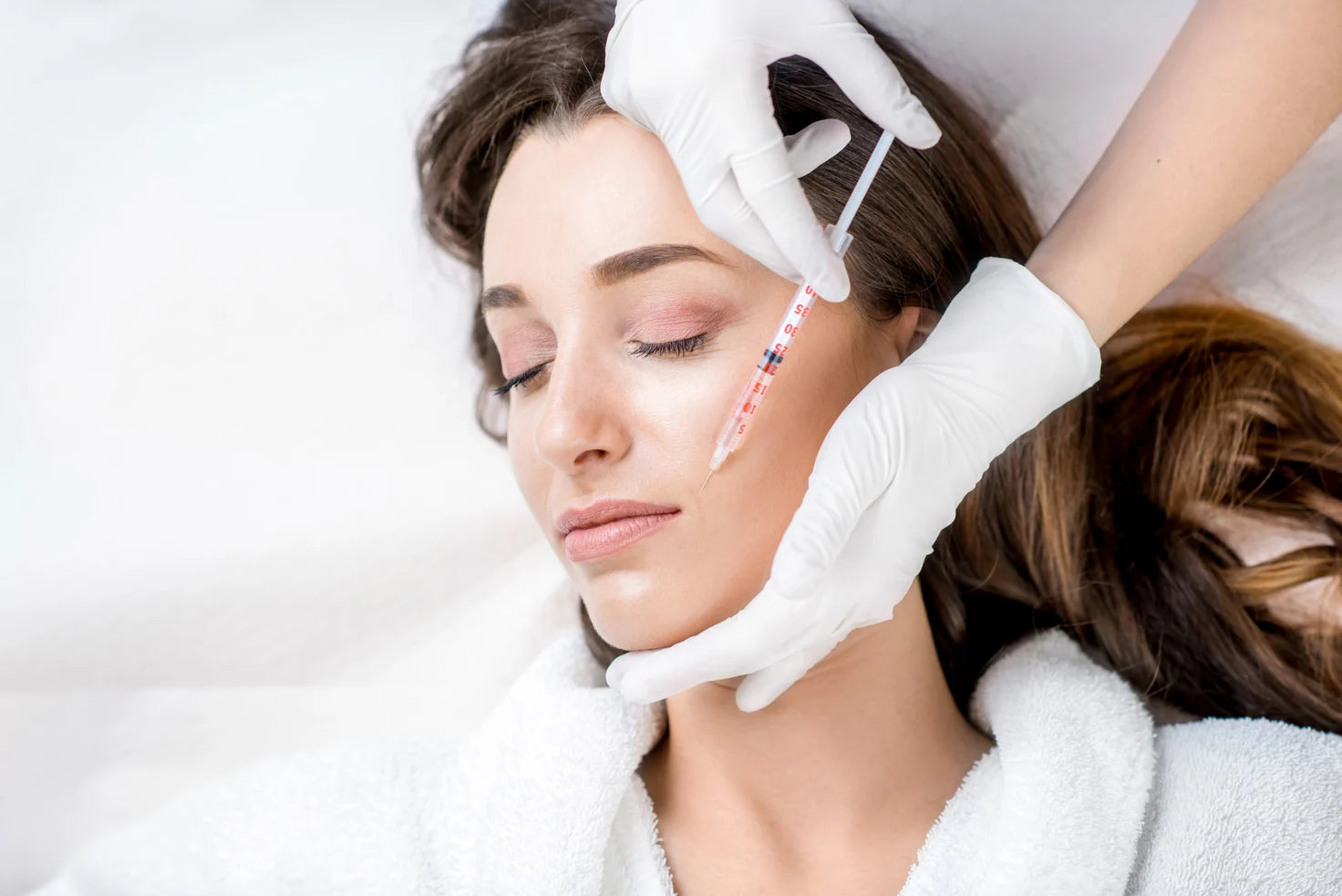 woman having face or cheek botox injection treatment on her cheek