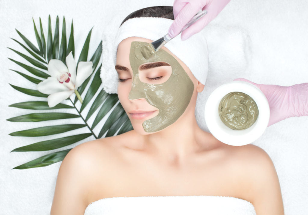 woman lying and having red out facial on spa