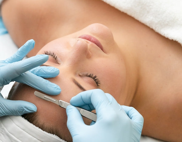 woman having dermaplaning procedure on forehead