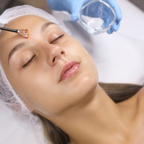 woman having facial treatment and mixture is being brushed on face