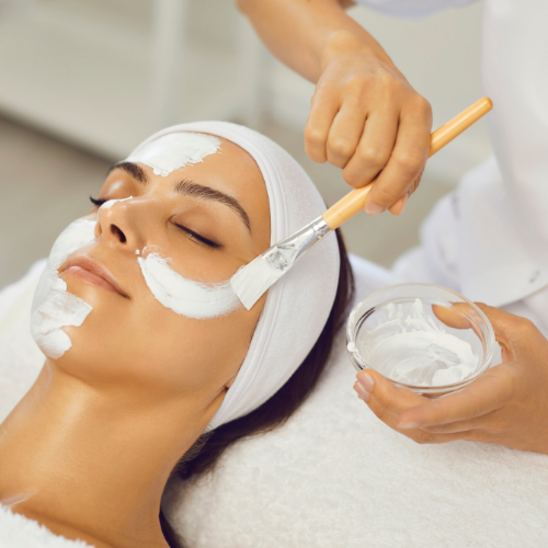 woman having facial treatment and mixture is being brushed on face
