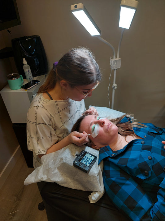 woman getting eyelash extension or treatment in a spa