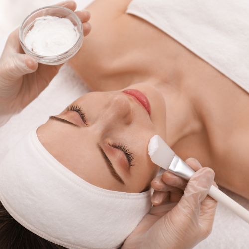 woman having chemical peel treatment cheeks are brushed with chemical peel cream