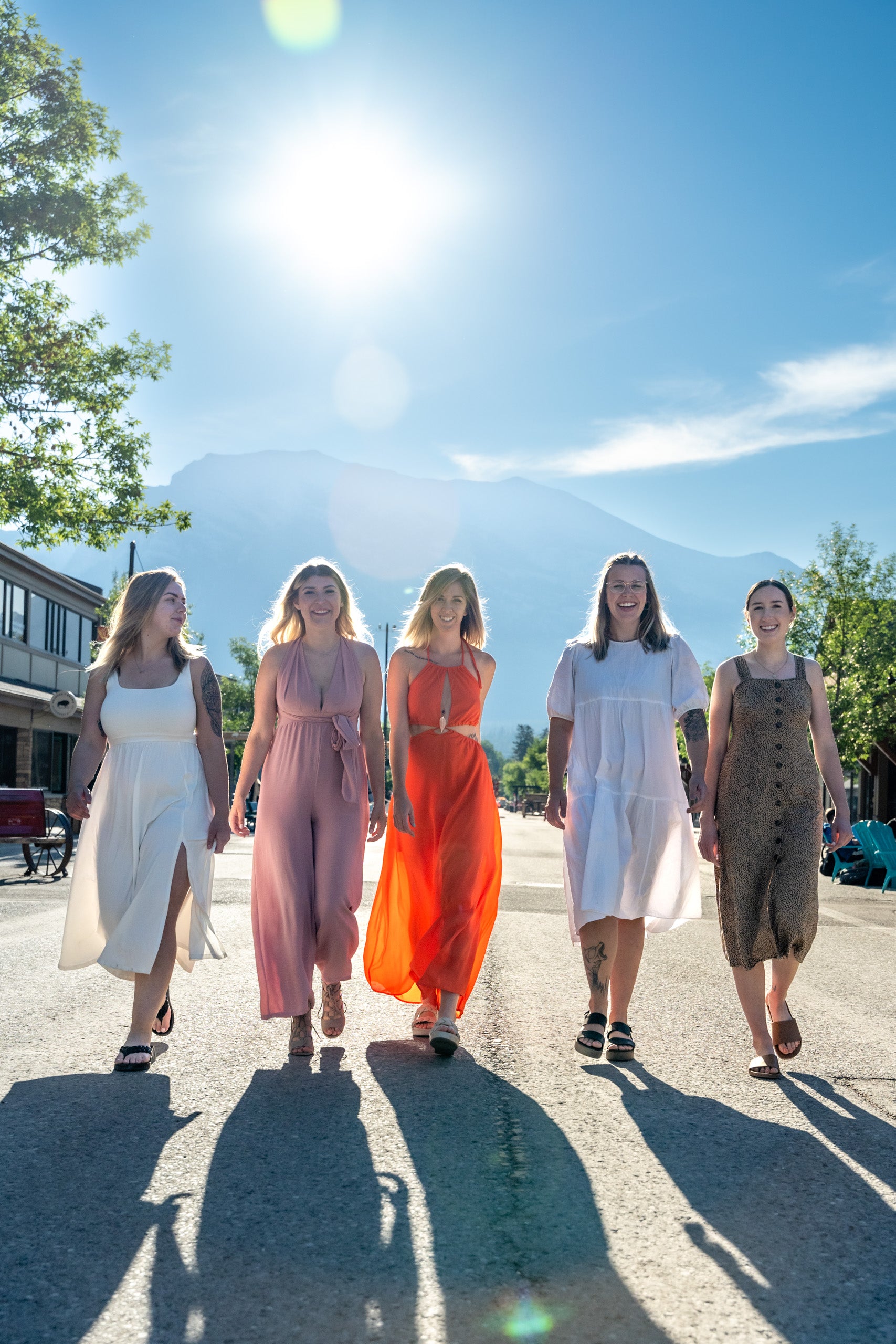 5 women in maxi dresses walking