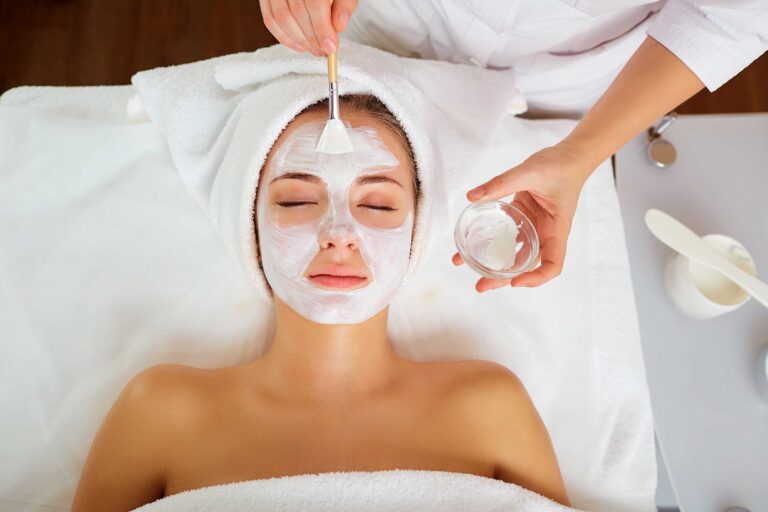 woman having chemical peel facial treatment on spa