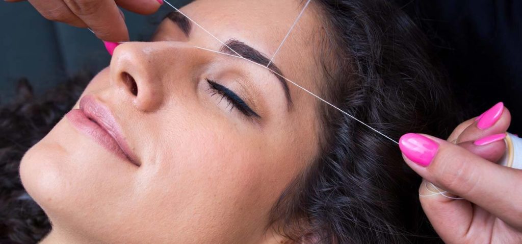 woman having eye brow threading